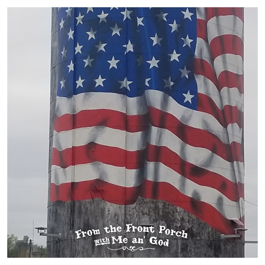A tower with the American Stars and stripes flag painted on the side. A text overlay on the image says "From the Front Porch with Me an' God".